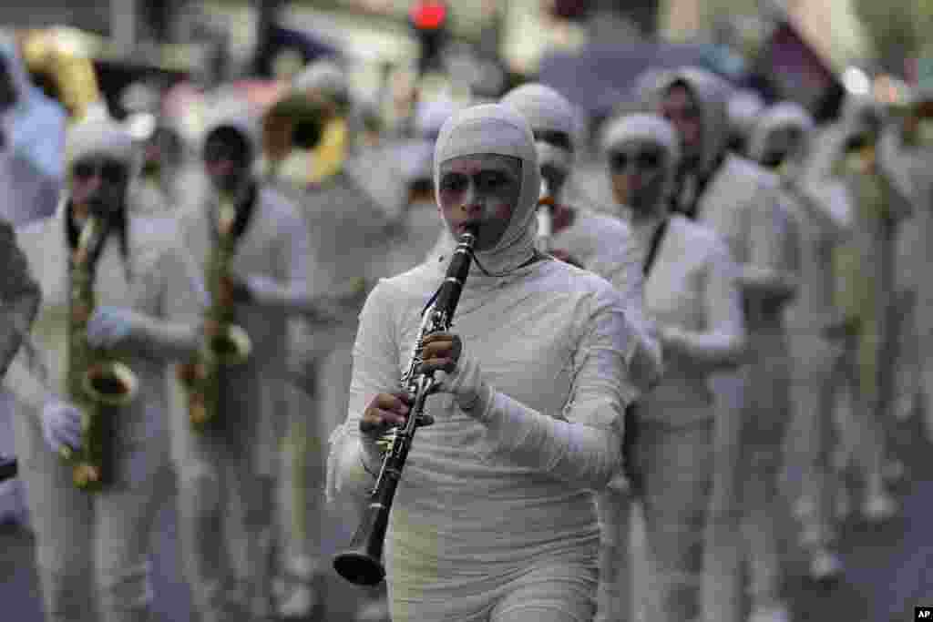 A marching band dressed as mummies plays during a parade of giant &quot;alebrijes,&quot; fantastical creatures made from papier-mache and painted in bright colors, in Mexico City, Oct. 21, 2017.
