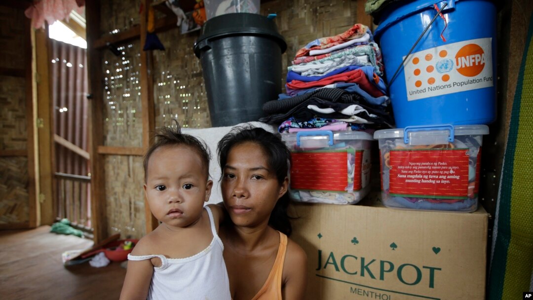 Typhoon survivor Emily Sagalis poses with baby Bea Joy inside her modest home near the Philippines’ coastal City of Tacloban, Nov.5, 2014. Bea Joy was named for her grandmother, Beatrice, who died in the storm.