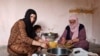 Ismahan, left, and her mother make traditional food using leaves plucked from trees, because they can not afford to buy them on May 20, 2020 in Istanbul. (Heather Murdock/VOA)