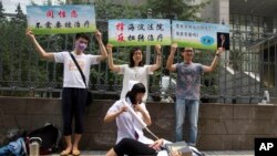 同性恋权利活动人士在北京一家法院外表演和抗议对同性恋实施的电击转化治疗。（2014年7月31日）