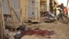 Nigerian troops gather evidence at the scene of suicide blasts that killed four people in Kano, Dec. 10, 2014. 