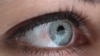Lights from a huge video screen are reflected in the eye of service assistant Nadine Thaemer at the booth of IBM during last preparations for the CeBIT, one of the World's biggest computer fairs for digital innovations and trends, in Hanover, Germany, Su