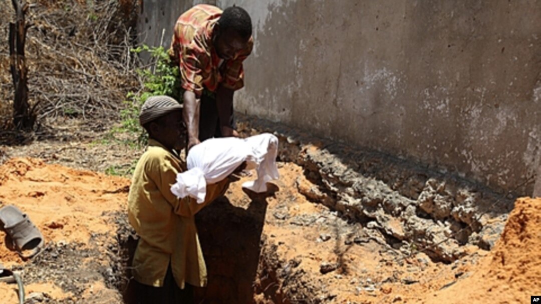 Internally displaced Somali men bury the body of a child who died of malnourishment in Hodan district, south of Mogadishu, Sept. 20, 2011.