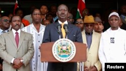 Kenya's Prime Minister Raila Odinga (C), flanked by members of the Coalition for Reforms and Democracy (CORD), addresses the media outside his office in Nairobi, March 16, 2013. 