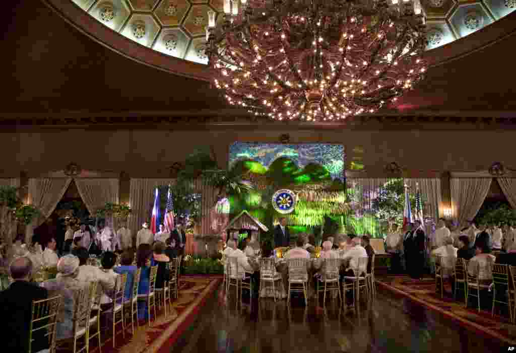 U.S. President Barack Obama, center, stands to speak as he attends a state dinner with Philippine President Benigno Aquino III at Malacanang Palace in Manila, Philippines, Monday, April 28, 2014. This is the last leg of president Obama's four-nation tour.