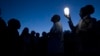 FILE - A group of activists, religious leaders and former prisoners listen to a former prisoner (C) talk about working the lime quarry during a visit to Robben Island.