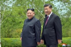 FILE - Chinese President Xi Jinping and North Korean leader Kim Jong Un walk during Xi's visit in Pyongyang, North Korea, in this picture released by North Korea's Korean Central News Agency, June 21, 2019.