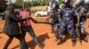 A supporter of Uganda's former Prime Minister Amama Mbabazi wrestles with the gun of a policeman, as riot police disperse a gathering in Jinja town in eastern Uganda September 10, 2015.