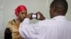 A detained Somali woman has her photograph taken before being fingerprinted and screened at the Kasarani sports stadium, which has been converted into a detention facility to hold those arrested during recent security crackdowns, near Nairobi in Kenya, April 9, 2014.