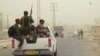 Armed Shi'ite volunteers, travel in a vehicle before taking their positions during a patrol after clashes with militants of the Islamic State, formerly known as the Islamic State in Iraq and the Levant on the outskirts of Samarra in Salahuddin province, July 13, 2014.