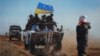 Lugansk, 23-fevral, 2022: Severodonetsk shahrida ukrain harbiylarining banneri oldidan o'tib ketayotgan ayol 