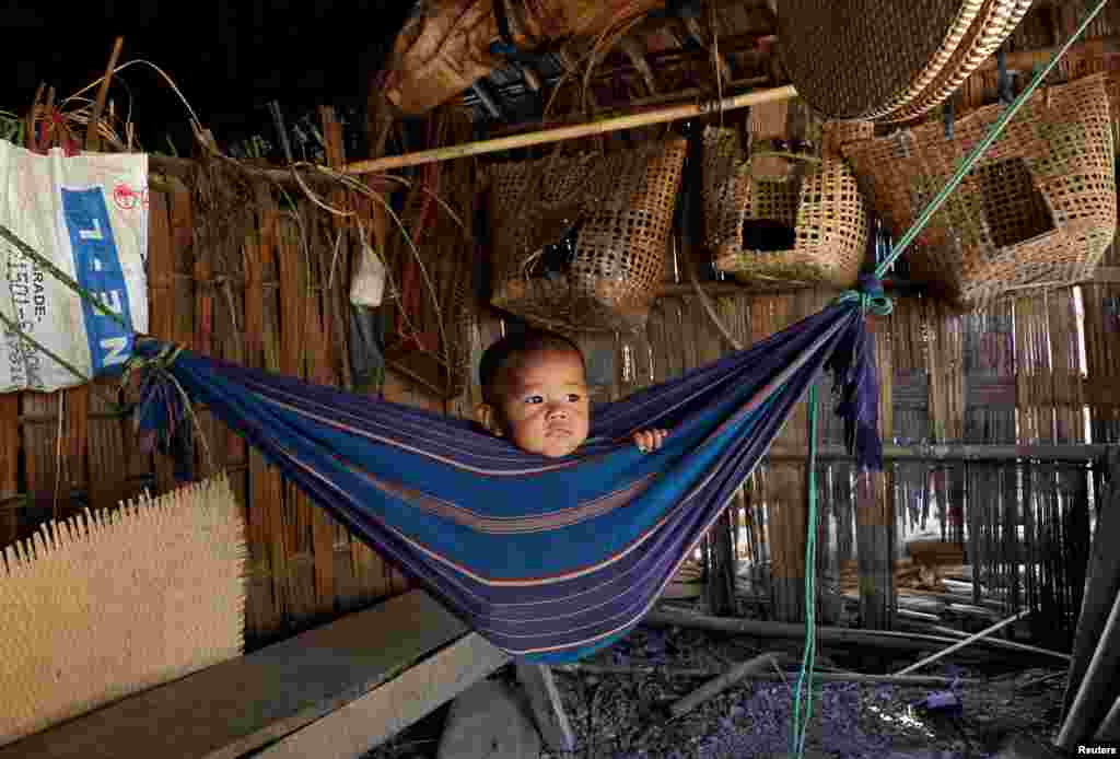 Tina Chakma, a six-month-old baby girl, plays in an improvised hammock inside her parents' house on the outskirts of Agartala, India.