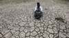 An Egyptian farmer squats down on cracked soil to show the dryness of the land due to drought in a farm formerly irrigated by the river Nile, in Al-Dakahlya, about 120 km (75 miles) from Cairo, June 4, 2013. 