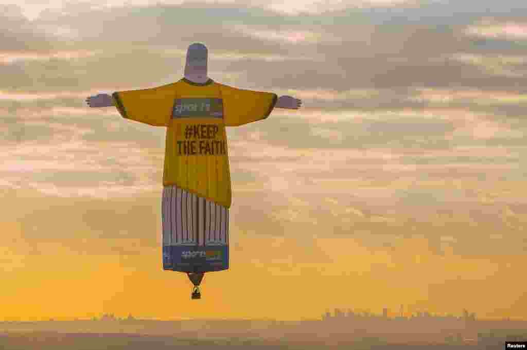 A balloon shaped in the famous &#39;Christ the Redeemer&#39; statue floats at sunrise above the Australian city of Sydney, Australia.