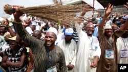 FILE - Members of All Progressives Congress party waves brooms the symbol of the party as former military ruler and Presidential aspirant Muhammadu Buhari, delivered a speech during the party convention in Lagos, Nigeria, April. 18, 2013. 
