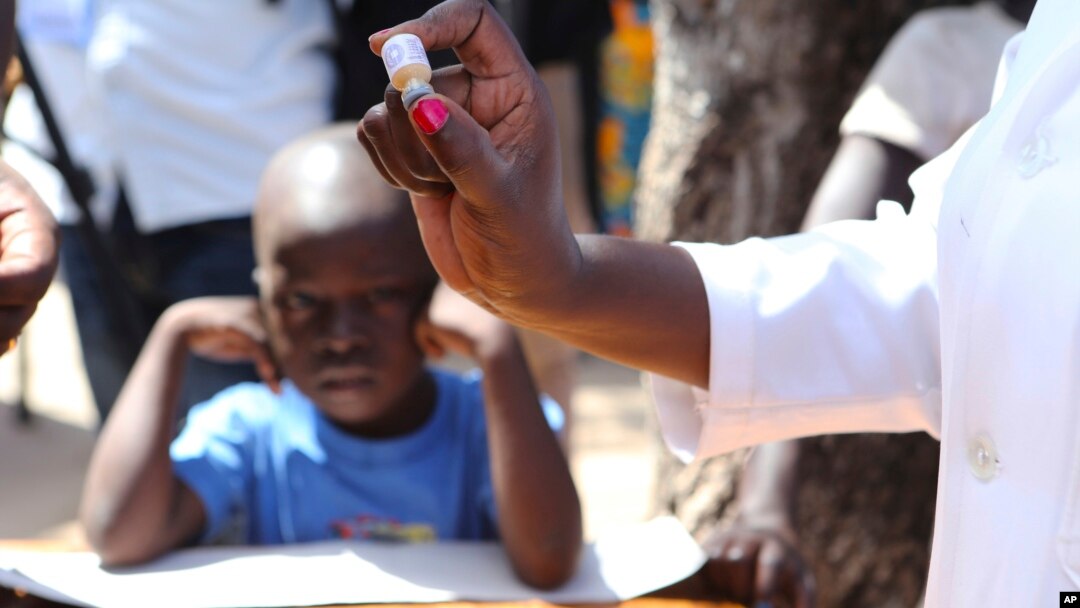 FILE - A health worker prepares to administer an oral cholera vaccination to a child at a camp for displaced survivors of cyclone Idai in Beira, Mozambique, April 3, 2019. 
