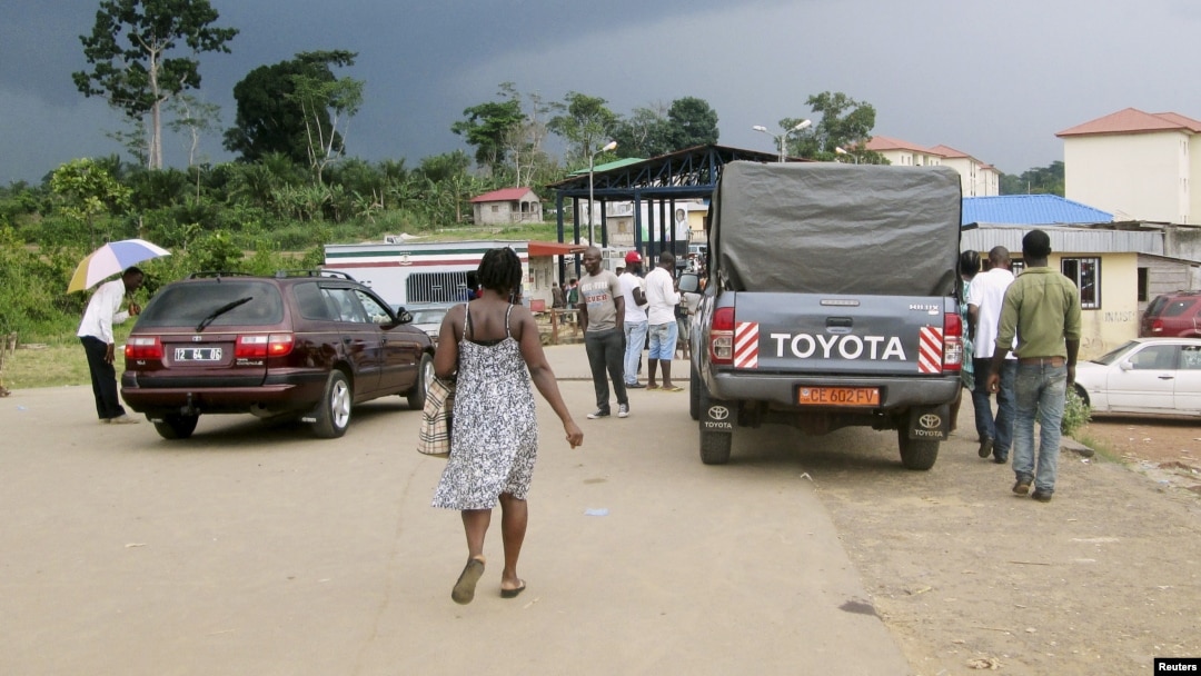 FILE - People wait to cross the border into Equatorial Guinea by car and by foot in Kye-Ossi, Cameroon, May 23, 2015. 