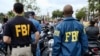 FILE - FBI agents look on as the gay pride parade kicks off in West Hollywood, Calif., June 12, 2016. 