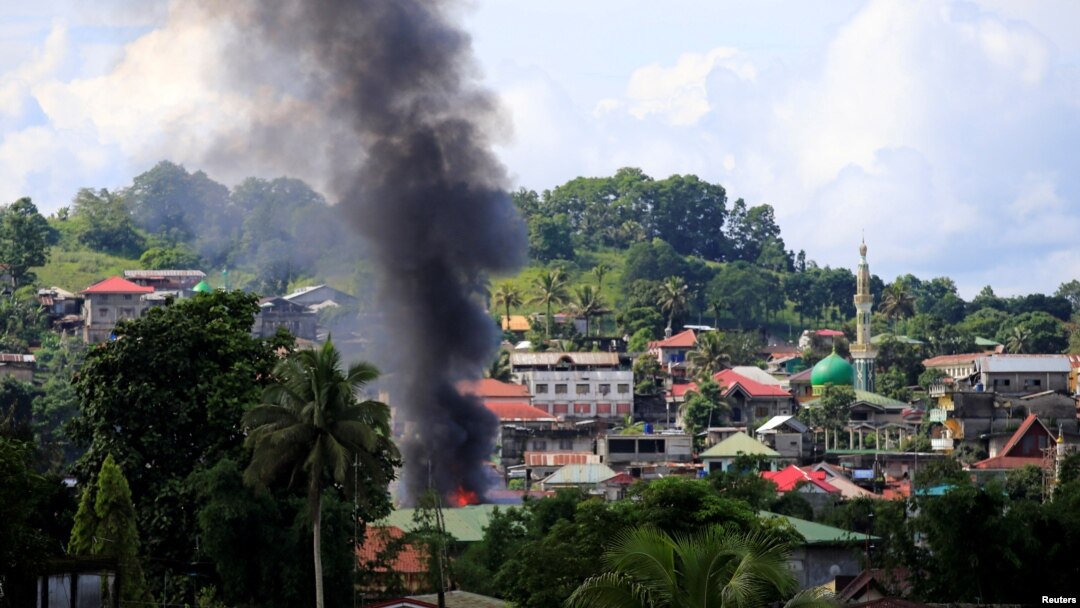 Smoke billowing from a burning building is seen as government troops continue their assault on insurgents from the Maute group, who have taken over large parts of Marawi City, Philippines, June 1, 2017. 