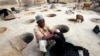 FILE - A man dyes fabrics in traditional styles in Kano, Nigeria.
