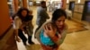 Women carrying children run for safety as armed police hunt gunmen who went on a shooting spree in Westgate shopping center in Nairobi, Sept. 21, 2013. 