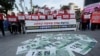 FILE - Fake bank notes showing images of U.S. President Donald Trump are displayed as protesters rally to oppose the U.S. demand for raising costs for stationing U.S. troops in South Korea, near the U.S. Embassy in Seoul, Oct. 22, 2019. 