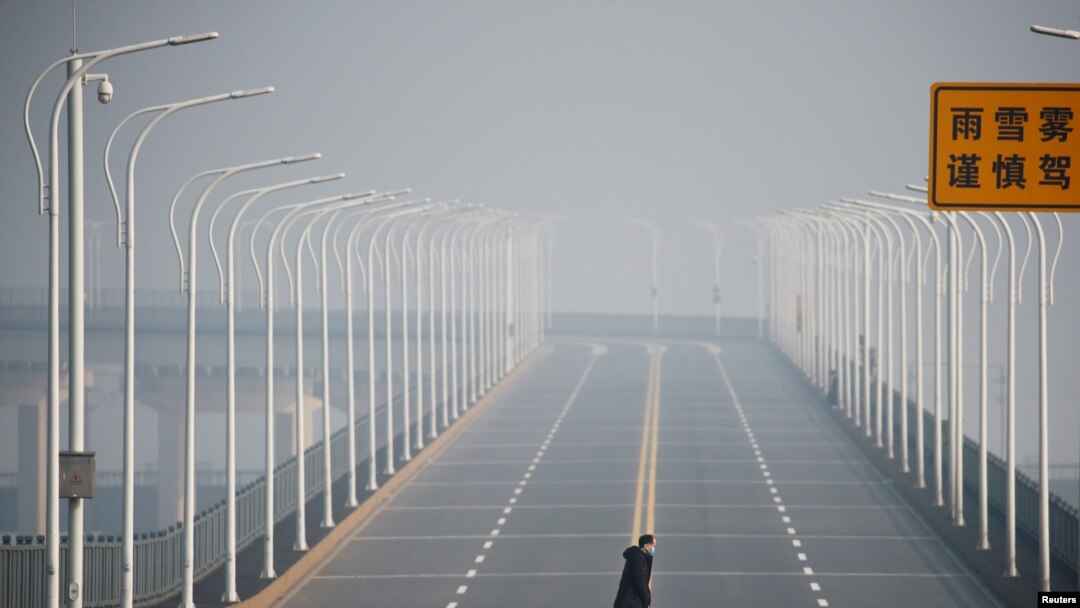 A man who arrived from Hubei province crosses the Jiujiang Yangtze River Bridge near a checkpoint in Jiujiang, Jiangxi province, China, as the country is hit by an outbreak of a new coronavirus, Jan. 31, 2020.