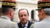 France's President Francois Hollande (C) speaks to military officials as he attends a ceremony to the memory of Stephane Hessel, at the Invalides in Paris, March 7, 2013.