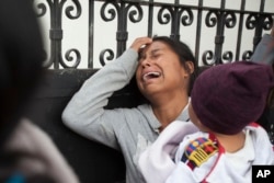 A relative of a youth who resided at the Virgin of the Assumption Safe Home wails as she waits for the release of the names of those who died in a fire at the shelter, outside the morgue where the bodies are being identified in Guatemala City, March 9, 20