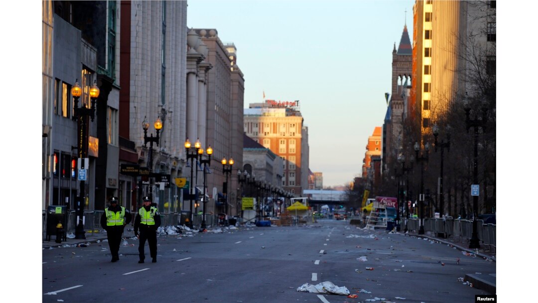 Two police officers walk down Boylston Street, away from the finish line of the Boston Marathon in Boston, Massachusetts April 16, 2013. Two bombs packed with ball bearings tore through crowds near the finish of the Boston Marathon, killing three people.