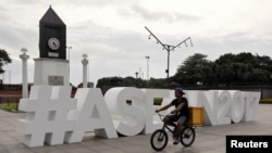 A man rides his bicycle past the ASEAN logo ahead of the 50th ASEAN Foreign Ministers meeting in Manila, Philippines, Aug. 2, 2017. 