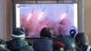 People watch a TV showing file images of North Korea's missile launch during a news program at the Seoul Railway Station in Seoul, South Korea, March 9, 2020.