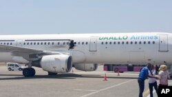In this photo taken Feb. 2, 2016, a hole is seen in a plane operated by Daallo Airlines as it sits on the runway of the airport in Mogadishu, Somalia. 