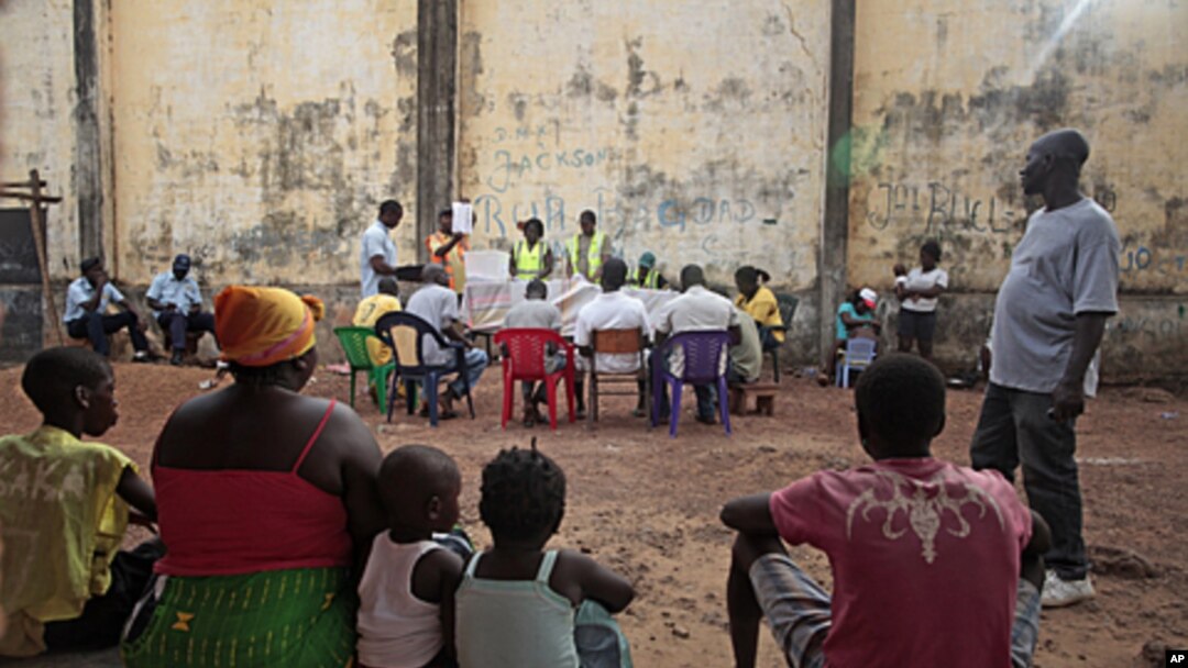 Local residents watch as ballots are counted at an outdoor polling station in Bissau, Guinea-Bissau, March 18, 2012. 