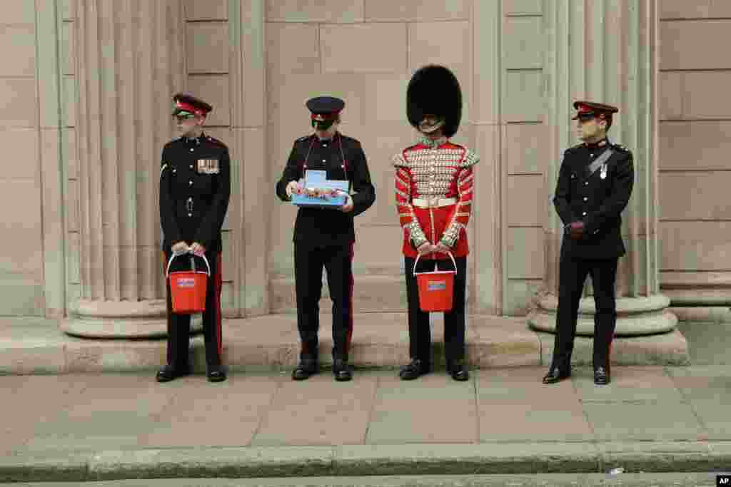 Members of the British military&#39;s Honorable Artillery Company collect donations for the annual poppy appeal ahead of Armistice Day outside the Bank of England in the City of London.