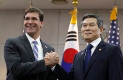 FILE - U.S. Defense Secretary Mark Esper, left, and South Korean Defense Minister Jeong Kyeong-doo, right, shake hands ahead of a meeting at Defense Ministry in Seoul, South Korea, Aug. 9, 2019.