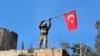 A soldier waves a Turkish flag as Turkish troops secure Bursayah hill, which separates the Kurdish-held enclave of Afrin from the Turkey-controlled town of Azaz, Syria, Jan. 28, 2018. 