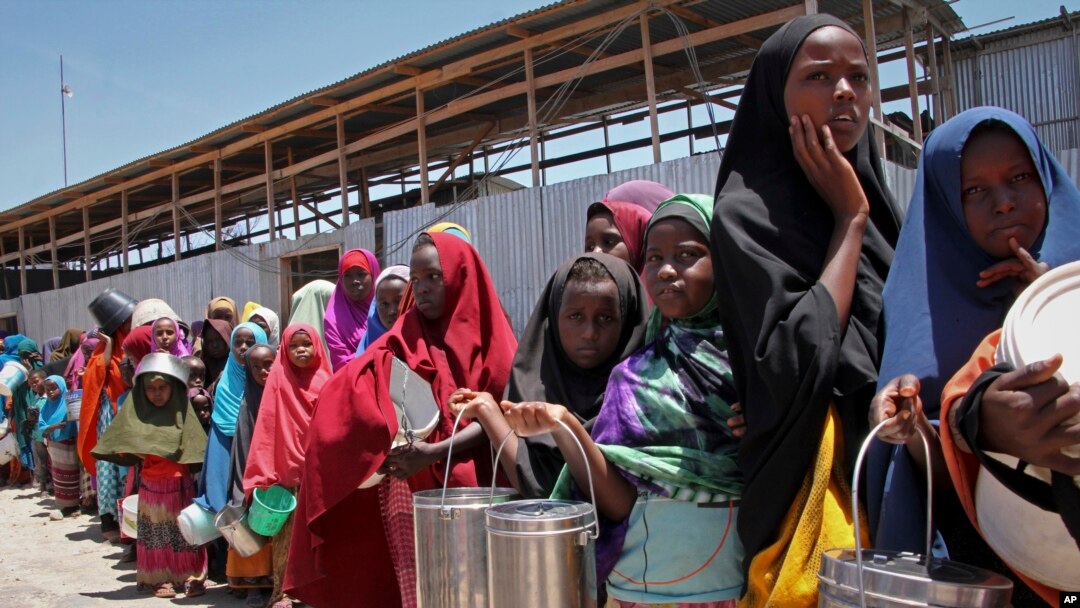 FILE - Watoto waliokimbia ukame katika eneo la kusini mwa Somalia wakiwa wanasubiri msaada wa chakula katika kituo cha kugawa chakula katika kambi moja Mogadishu, Somalia. 