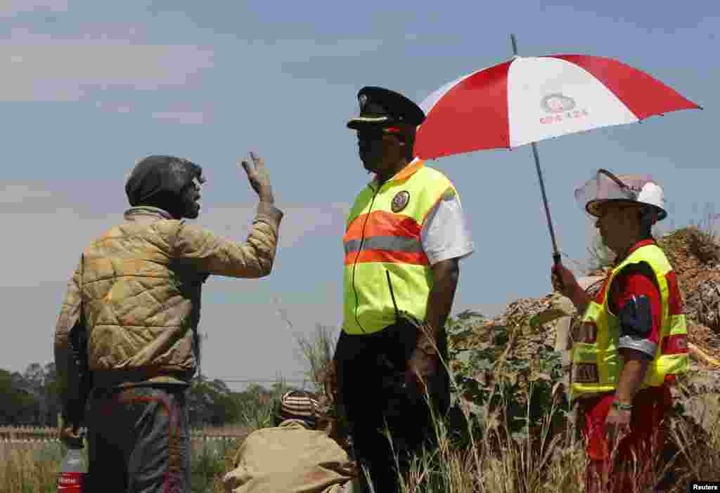 A suspected illegal miner talks to emergency personnel after emerging from an abandoned gold shaft in Benoni, east of Johannesburg, South Africa, Feb. 17, 2014.&nbsp;