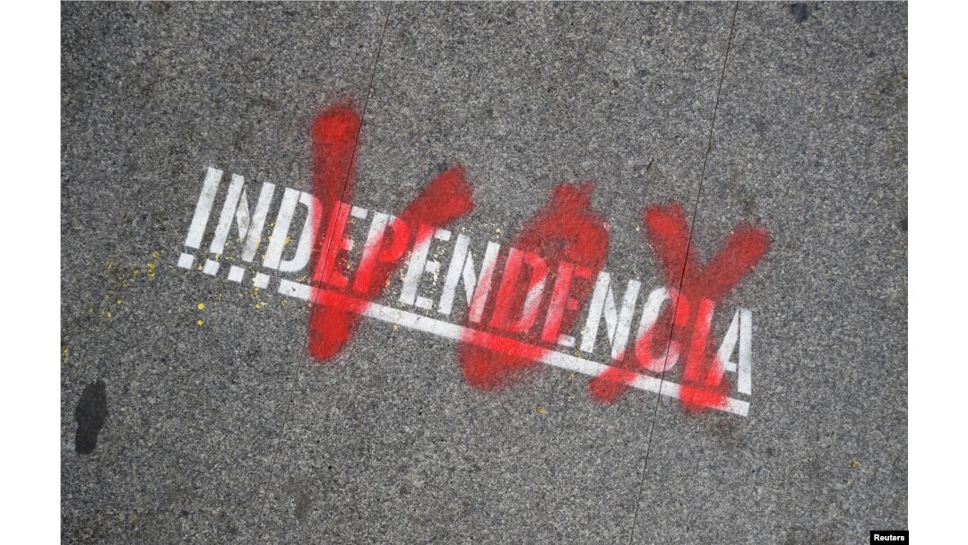 FILE - The name of the Spanish right-wing party Vox is sprayed over the graffiti stencil reading "Independence" on sidewalk in Barcelona, Spain, Dec. 12, 2018.