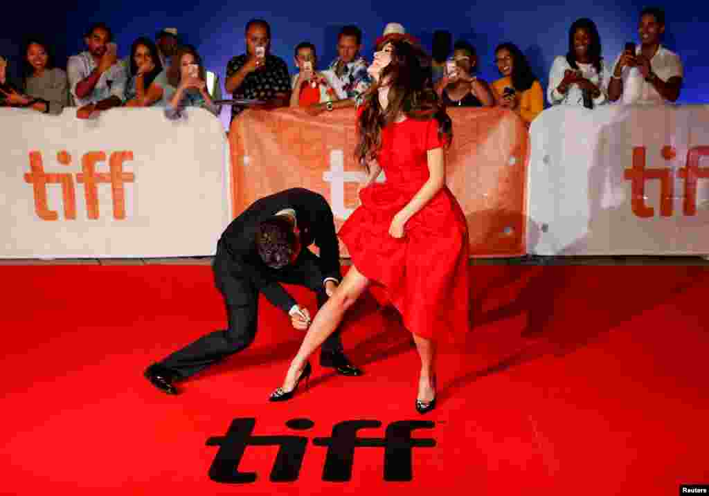 Oscar Isaac pretends to autograph Charlotte Le Bon's leg as they arrive on the red carpet for the film The Promise during the 41st Toronto International Film Festival (TIFF), in Toronto, Canada, Sept. 11, 2016.