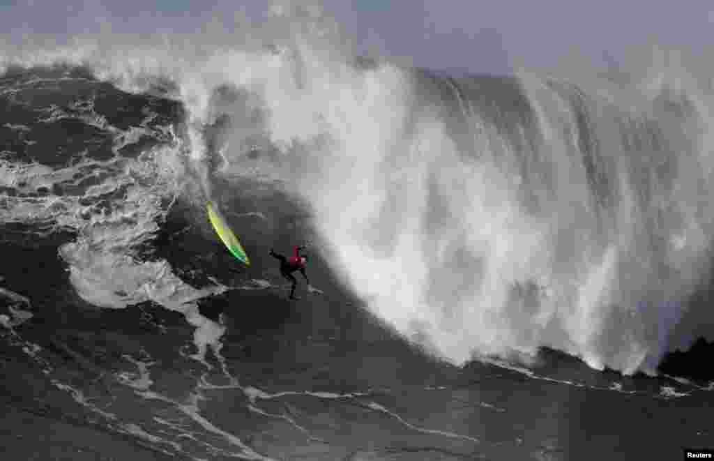 A surfer wipes out on a large wave at Praia do Norte in Nazare, Portugal, Dec. 30, 2017.