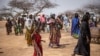 FILE - Refugees walk in a camp for internally displaced persons, in northern Burkina Faso, June 20, 2021.