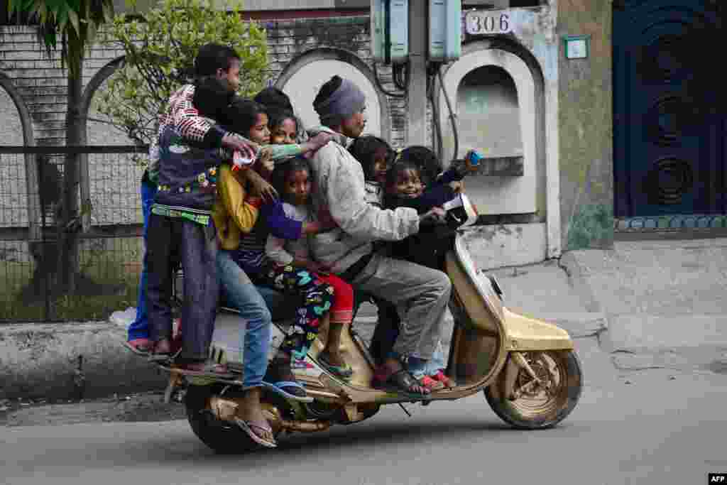 Children ride on a motorbike on a street in Jalandhar, India.