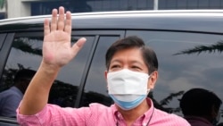 FILE- Ferdinand 'Bongbong' Marcos Jr., center, waves to supporters after filing his certificate of candidacy for next year's presidential elections Oct. 6, 2021, in Manila, Philippines.