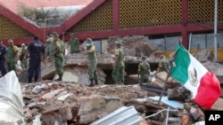 FILE - Soldiers remove debris from a partly collapsed municipal building felled by a massive earthquake in Juchitan, Oaxaca state, Mexico, Sept. 8, 2017.