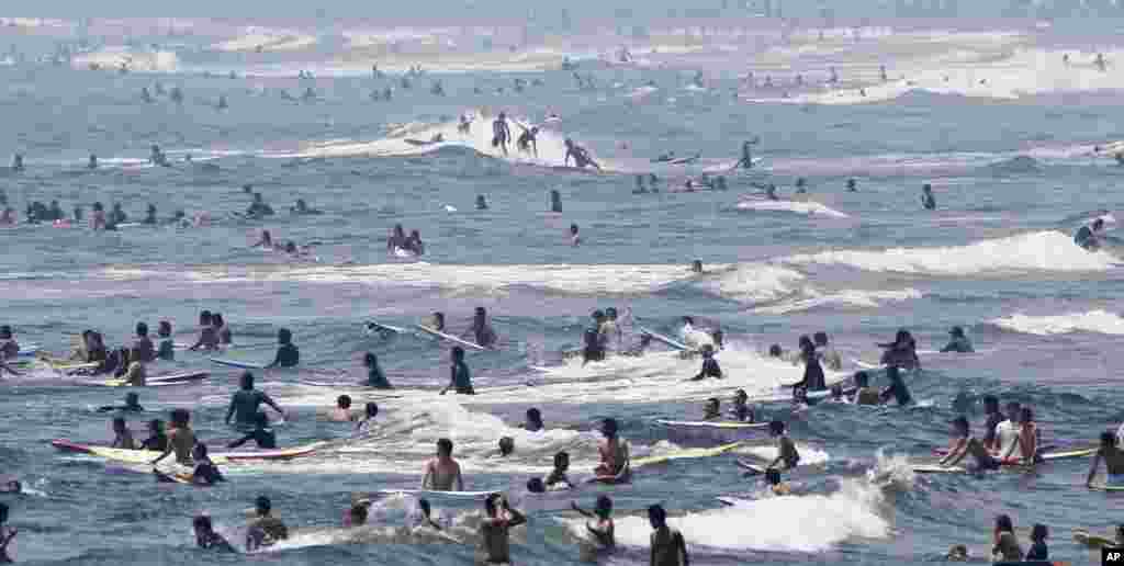 Surfers ride waves at Shonan beach in Fujisawa city, west of Tokyo, Japan. Heat wave continues through out Japan as temperature sores to 35 degrees Celsius (95 degrees Fahrenheit) in the Tokyo metropolitan area, according to the Meteorological bureau.