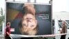 Employees of a billboard advertising company carry a disassembled election poster of Germany's Christian Democratic Union (CDU) party with the portrait of German Chancellor Angela Merkel in Berlin on Sept. 25, 2017.
