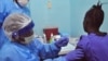 A woman is injected by a health care worker, left, as she takes part in an Ebola virus vaccine trial in Monrovia, Liberia, Monday, Feb. 2, 2015. 