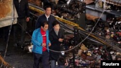 韩国总统朴槿惠12月1日视察一个市场发生火灾后的现场。